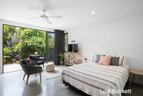 a bedroom with a bed and a sliding glass door at Crows Nest in Lennox Head