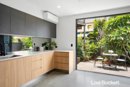 an open kitchen with a view of a patio at Crows Nest in Lennox Head