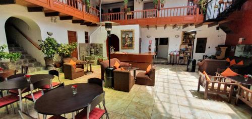 Habitación grande con mesas y sillas en un edificio en HOTEL AMTALLPA San Blas Inn, en Cusco