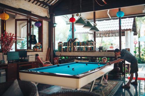 a man playing pool in a room with a child at Godiva Villa Phu Quoc in Phu Quoc