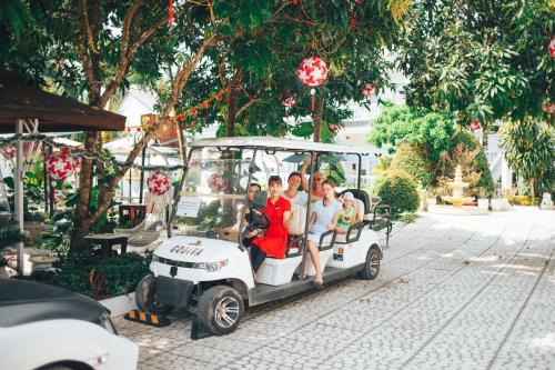 a group of people riding on a golf cart at Godiva Villa Phu Quoc in Phu Quoc