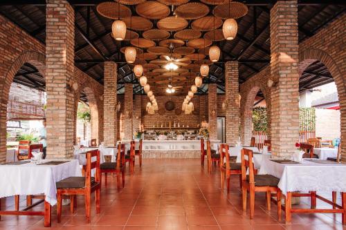 un restaurante con mesas y sillas y un bar en Palm Hills Resort, en Phu Quoc