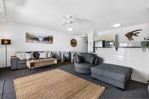 a living room with a couch and a table at Rovera Apartments in Maroochydore