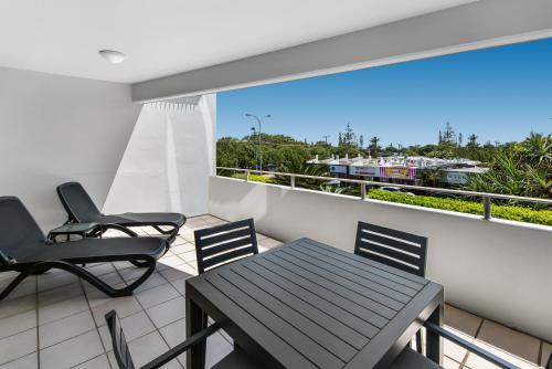 a balcony with a table and chairs and a view at Rovera Apartments in Maroochydore