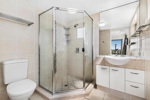 a bathroom with a shower and a toilet and a sink at Rovera Apartments in Maroochydore