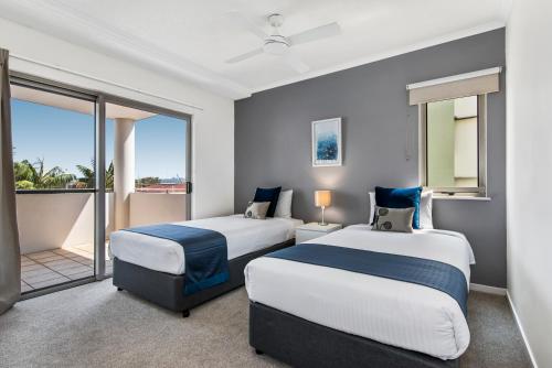two beds in a room with a balcony at Rovera Apartments in Maroochydore