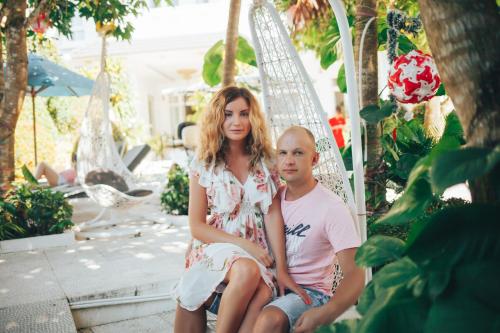 a man and a woman sitting on a swing at Godiva Villa Phu Quoc in Phu Quoc
