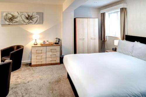 Habitación de hotel con cama, escritorio y silla en Best Western Weymouth Hotel Rembrandt en Weymouth