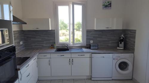una cucina con lavello e lavatrice di Gîte "Le Couchant" a Gras
