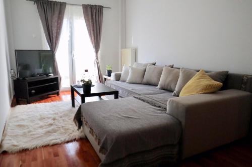 a living room with a couch and a television at Black & Yellow Apartment at City Center in Ioannina