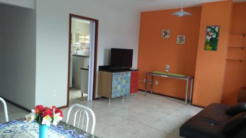 a living room with a table and a television at Cobertura Aconchegante Itaúna in Saquarema