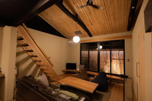 ein Wohnzimmer mit einer Treppe und einer Couch in der Unterkunft ORI stay and living in Kyoto