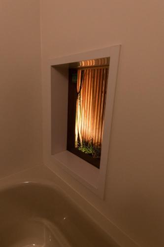 a bath tub with a window in a bathroom at ORI stay and living in Kyoto