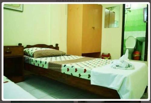 Schlafzimmer mit einem Bett mit einem Tisch und einem Spiegel in der Unterkunft Necy's Homestay in Kāman