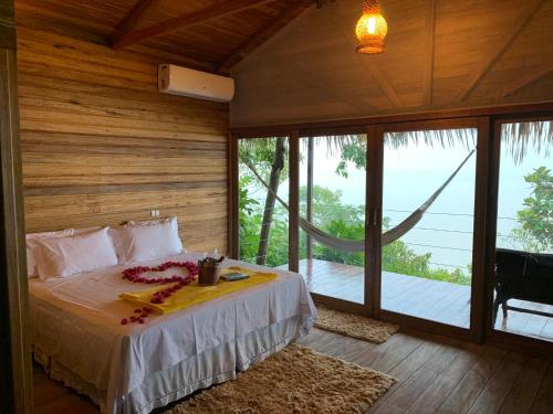 ein Schlafzimmer mit einem Bett in einem Zimmer mit Fenstern in der Unterkunft Alta Vista Amazon Lodge in Manacapuru