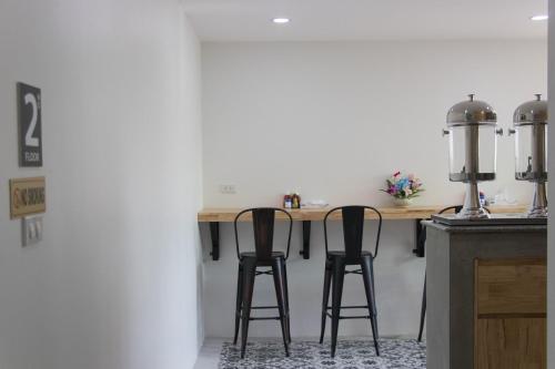 una cocina con 2 taburetes de barra en Puak Taem Boutique Hotel, en Chiang Mai