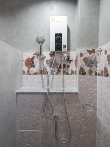 a shower with a blow dryer in a bathroom at Puak Taem Boutique Hotel in Chiang Mai