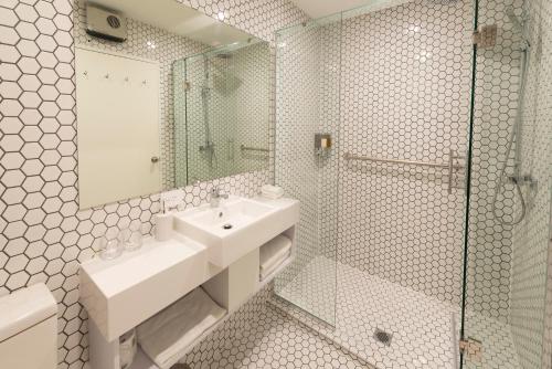 a bathroom with a sink and a glass shower at V Motel in Christchurch