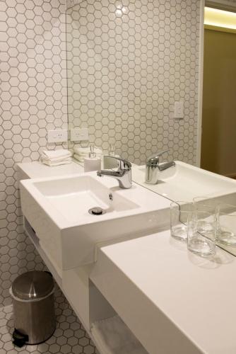 a white bathroom with a sink and a mirror at V Motel in Christchurch