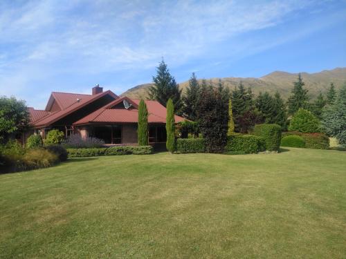ein Haus mit einer großen Wiese davor in der Unterkunft Mountain Majesty on Orchard-Wanaka Holiday Home in Wanaka