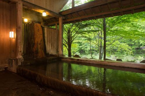 a pool of water in a building with trees at Yumoto Choza in Takayama
