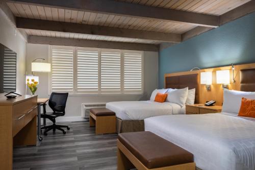 a hotel room with two beds and a desk at Prodigy Hotel, a Days Inn by Wyndham in Davis
