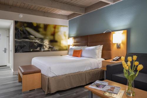 a hotel room with a large bed and a desk at Prodigy Hotel, a Days Inn by Wyndham in Davis