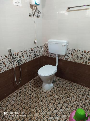 a bathroom with a toilet and a shower at VANASIRI COTTAGE (Tourist Home) in Dharmastala