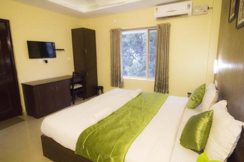 a bedroom with a large bed and a window at North Centre in Cochin