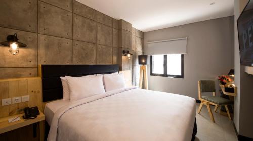 a bedroom with a large white bed in a room at Ayaartta Hotel Malioboro in Yogyakarta