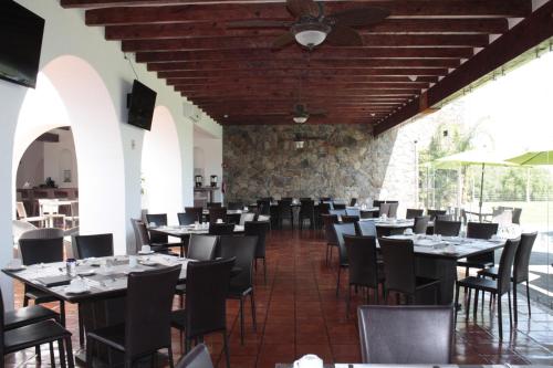 a dining room with tables and chairs and a ceiling at Hotel Villa Mexicana Golf & Equestrian Resort in Villa del Pueblito