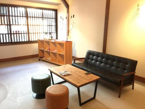 a living room with a couch and a coffee table at KINOSAKI KNOT in Toyooka