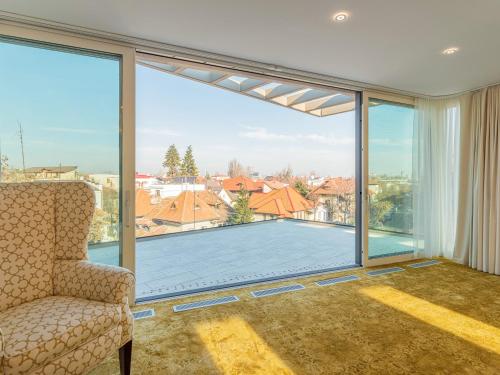 a living room with a large window with a view of a pool at Pergola Boutique Hotel in Bucharest