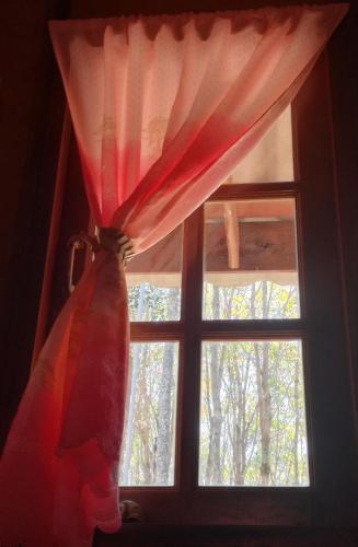 a window with a red curtain in a room at Mr Bao Homestay & Bungalows in Ko Yao Noi