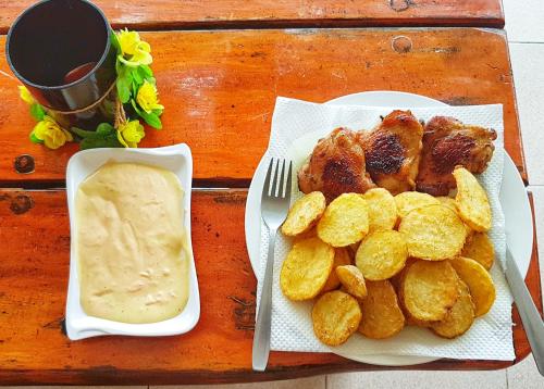 a table with a plate of food and a bowl of dipping sauce at WHITE BEACH GUEST HOUSE in Puerto Galera