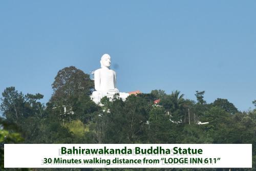 a large white statue sitting on top of trees at Lodge in 611 in Kandy