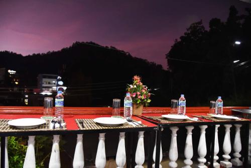 a table with plates and water bottles on a fence at Lodge in 611 in Kandy