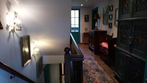 a hallway with a staircase and a living room at Die schlafende Goass in Bischofswiesen