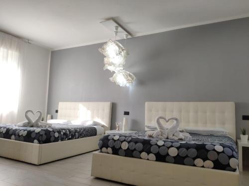 two beds in a bedroom with a chandelier at Sweet House Self Check-in 24h in Cavallasca