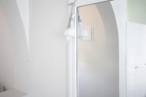 ducha con puerta de cristal y cortina de ducha en Ersi Villas, en Firostefani