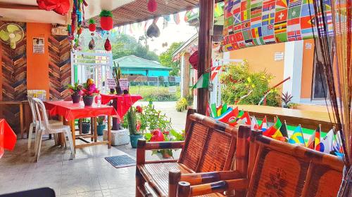 a patio with a table and a bench with colorful flags at WHITE BEACH GUEST HOUSE in Puerto Galera