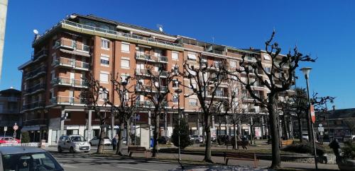 un gran edificio de ladrillo con árboles delante de él en Beautiful View - Centre Ville CIR 004-0250-00005, en Borgo San Dalmazzo