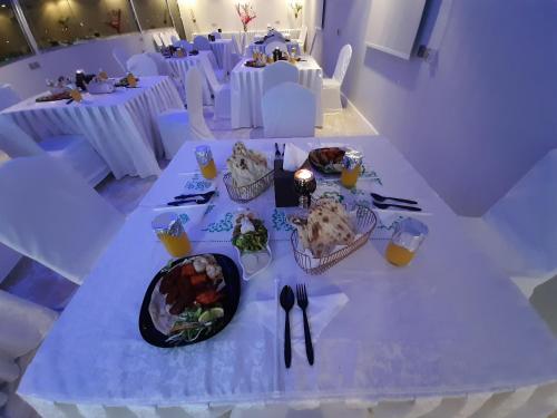a white table with plates of food on it at Qasr Alshamal Hotel in Arar
