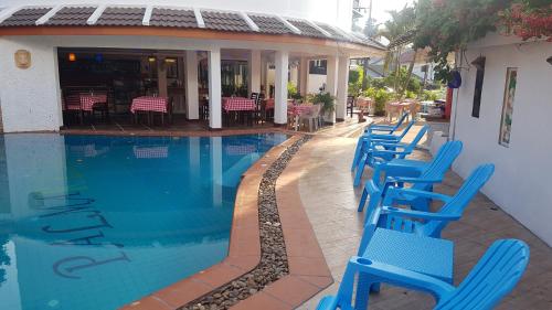a row of blue chairs sitting next to a swimming pool at La Capannina Hotel Patong in Patong Beach