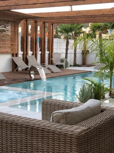 a swimming pool with wicker chairs and a swimming pool at Espacio Botavara in San José