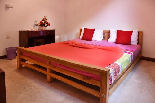 a bedroom with a large wooden bed with red sheets at Lodge in 611 in Kandy