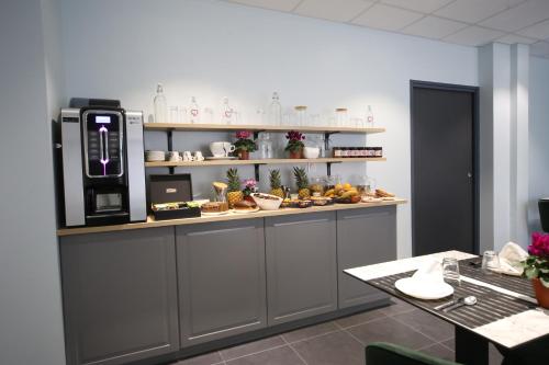 eine Küche mit einer Theke mit Lebensmitteln darauf in der Unterkunft Hôtel Fontaine Argent - Centre Ville in Besançon
