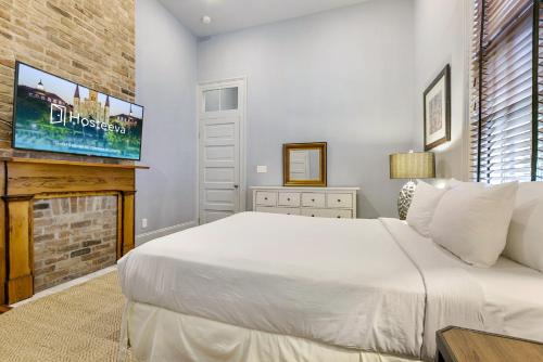 um quarto com uma cama branca e uma lareira em Hosteeva - Double on Martin Luther King Jr em Nova Orleans