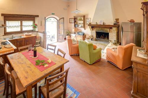 cocina y sala de estar con mesa y chimenea en Podere Fontecastello, en Montepulciano