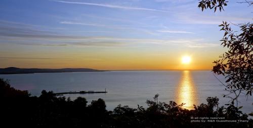 a sunset over a large body of water at B B Guesthouse TIHANY in Tihany